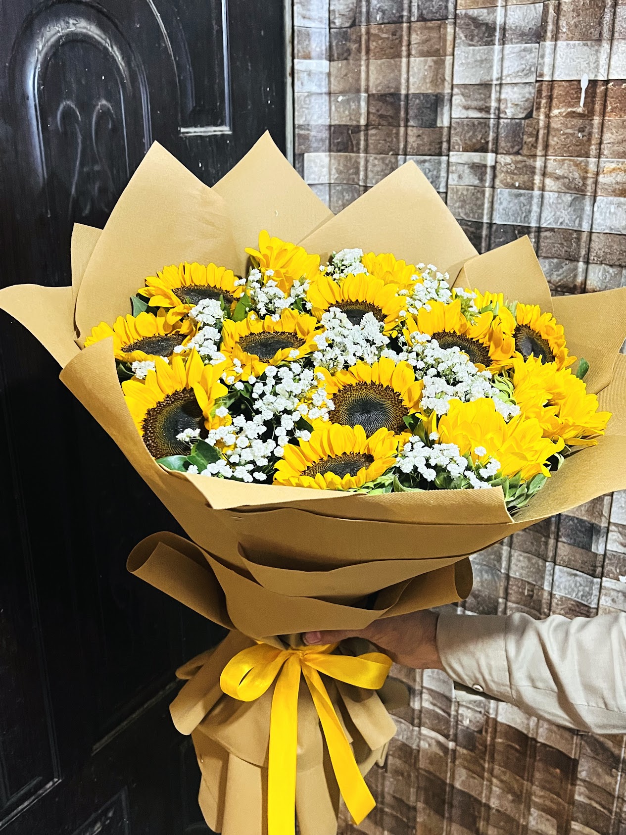 Yellow sunflower bouquet with white baby’s breath and kraft wrapping by Rukhsar Flowers in Karachi